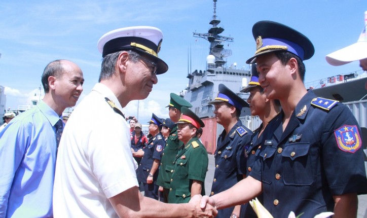 A crew member of the Japan Coast Guard vessel (L) shakes hands with a representative of the Vietnam Coast Guard on July 25, 2016. 
