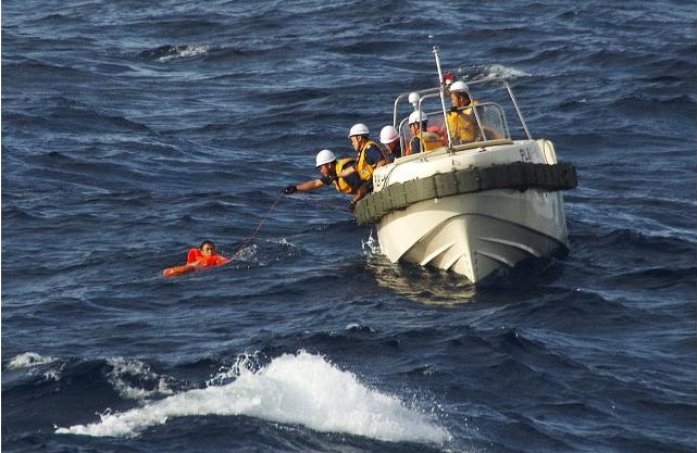 Japan Coast Guard personnel pull Chinese crew from the ocean after their fishing boat collided with a cargo ship and sank near the Senkaku Islands - Aug11,2016