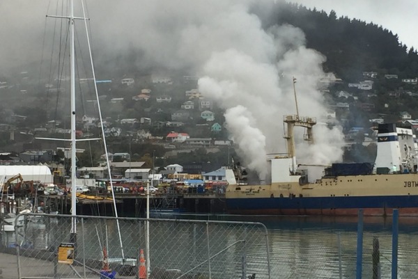 Smoke billowing from the fishing vessel on fire at Lyttelton Port of Christchurch, New Zealand on Apr 18, 2016