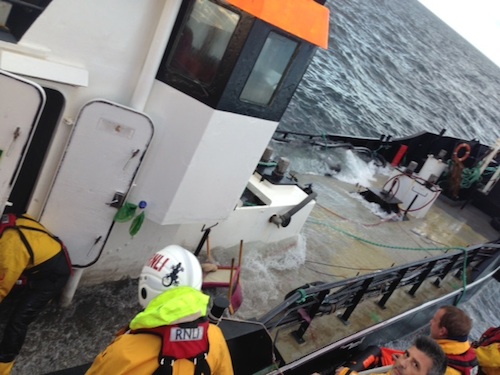 Members of RNLI lifeboat team assisting the Erin Wood's crew with a salvage pump