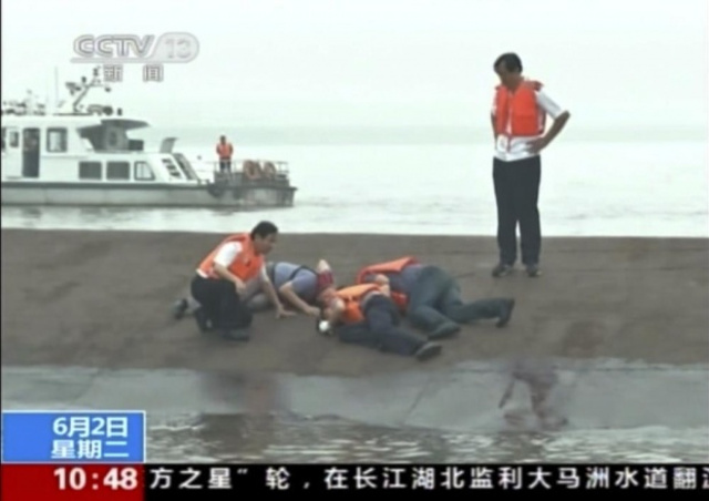 Rescue workers listen for a response to their tapping on the hull of a capsized ferry